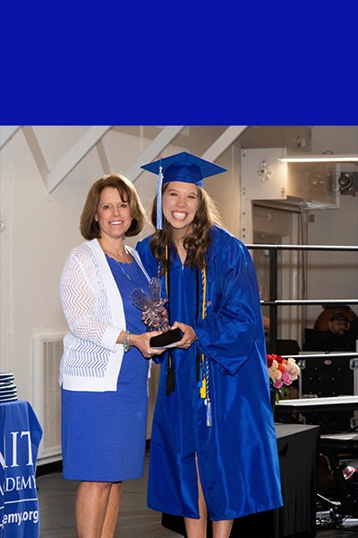 SCA Class of 2023 Linda Harrelson Scholarship recipient Katie Coats pictured right is presented with the Linda Harrelson Legacy of Student Leadership Scholarship by Harrelson during the 2022 Commencement Ceremony. Katie plans to attend Abilene Christian University and study Elementary & Early Education.
