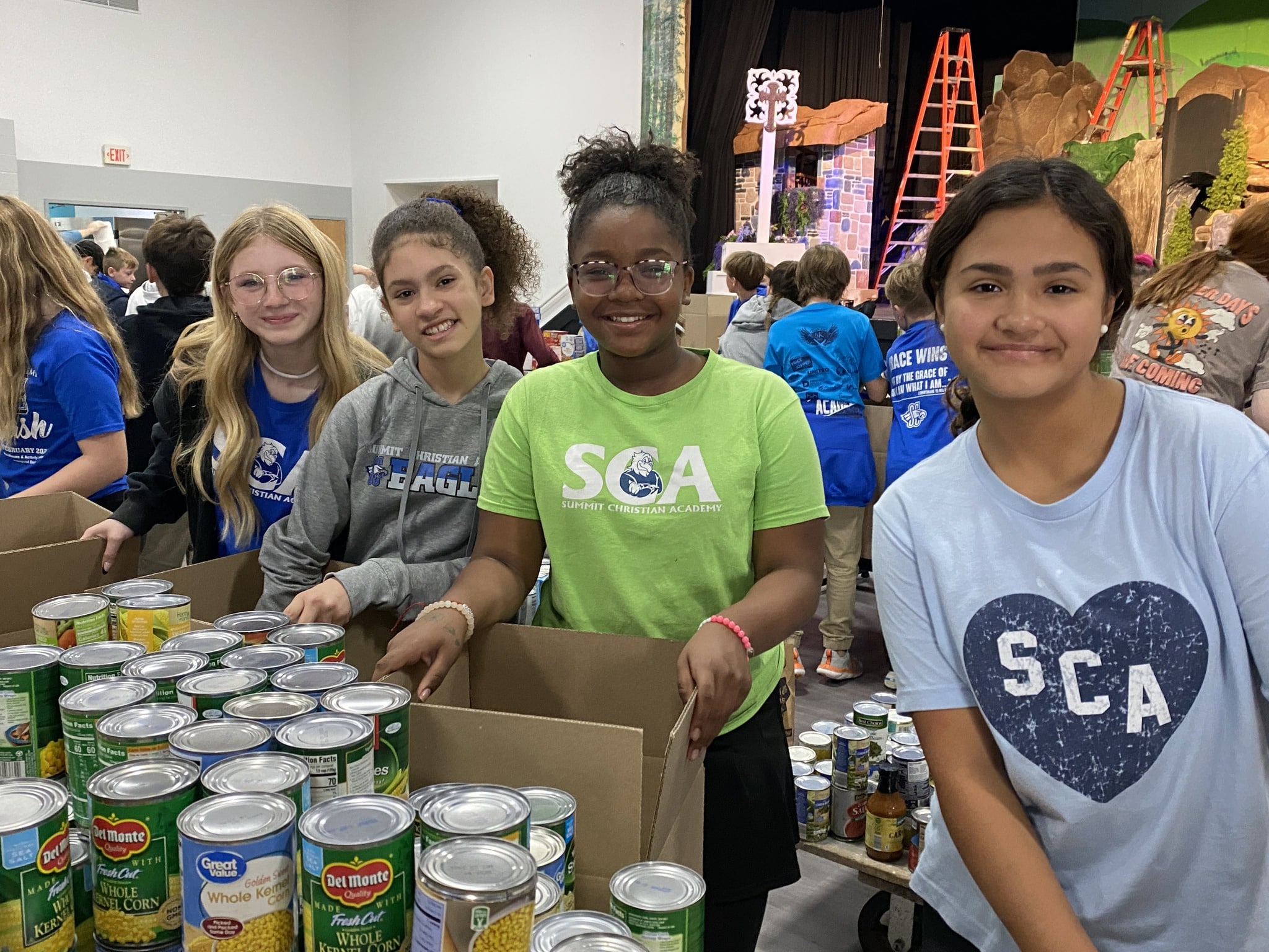 SCA sixth grade students (l-r) Kimber Goppert, Violet Gentemen, Abrianna Franklin, and Jordyn Mann organize and pack some of the over 1,500 cans of vegetables donated by SCA students in the 15th annual Elementary Food Drive.