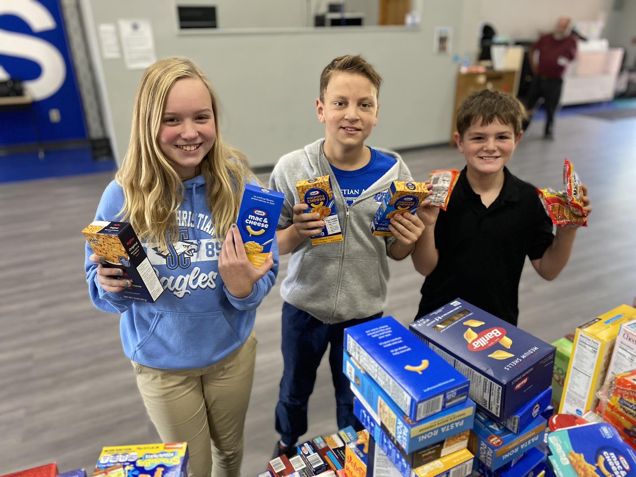 SCA sixth grade students (l-r) Olivia Mick, Luke Montgomery, and Nicholas Breshears organize and pack some of the over 1,600 units of boxed foods donated by SCA students in the 15th annual Elementary Food Drive.