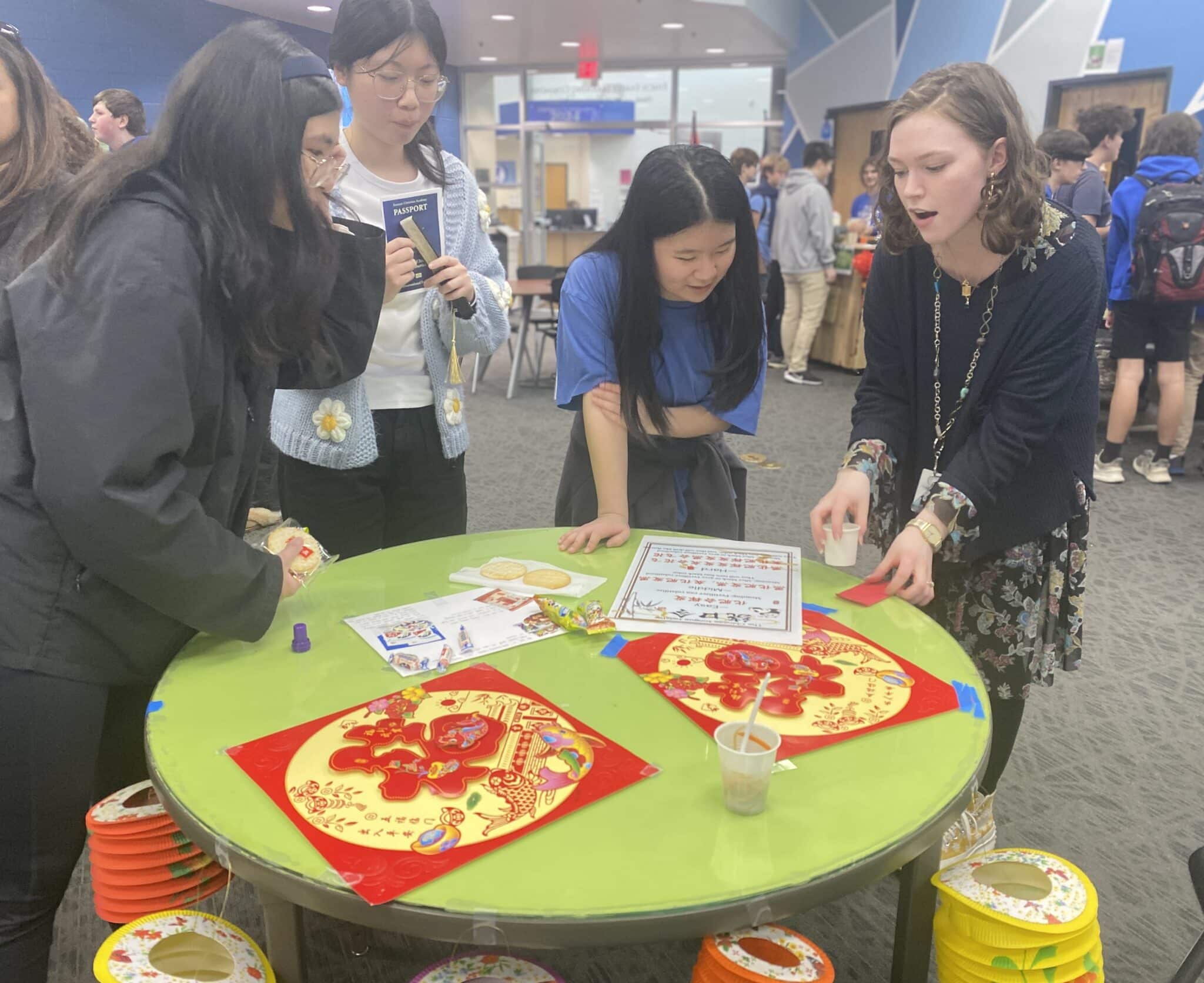 SCA international students help participants learn about their culture through a Chinese tongue twister. (L-R) Christine Xiong, Amber Zhang, and Emma Bao teach Secondary English teacher Abigail Stolberg a challenging Chinese tongue twister at the SCA International Experience.