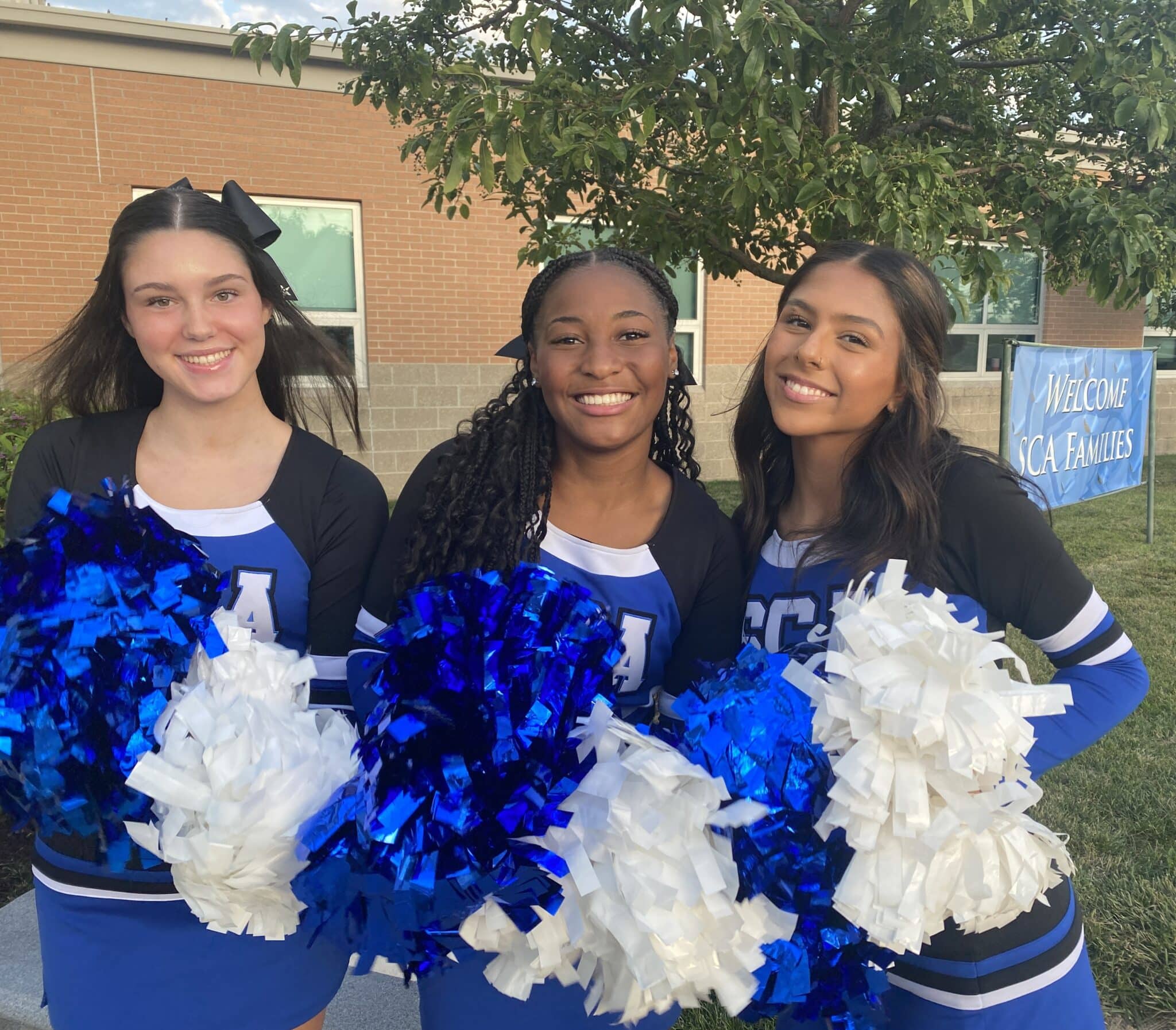 SCA freshman Violet Glaze, sophomore Sophie McCanse, and senior Arin Nieto cheered on the 2024-25 school year in which SCA was named the top private school in the Kansas City area for the third year in a row.